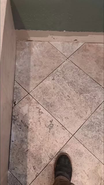 Tile floor set on the diagonal with the grout lines running corner to corner.