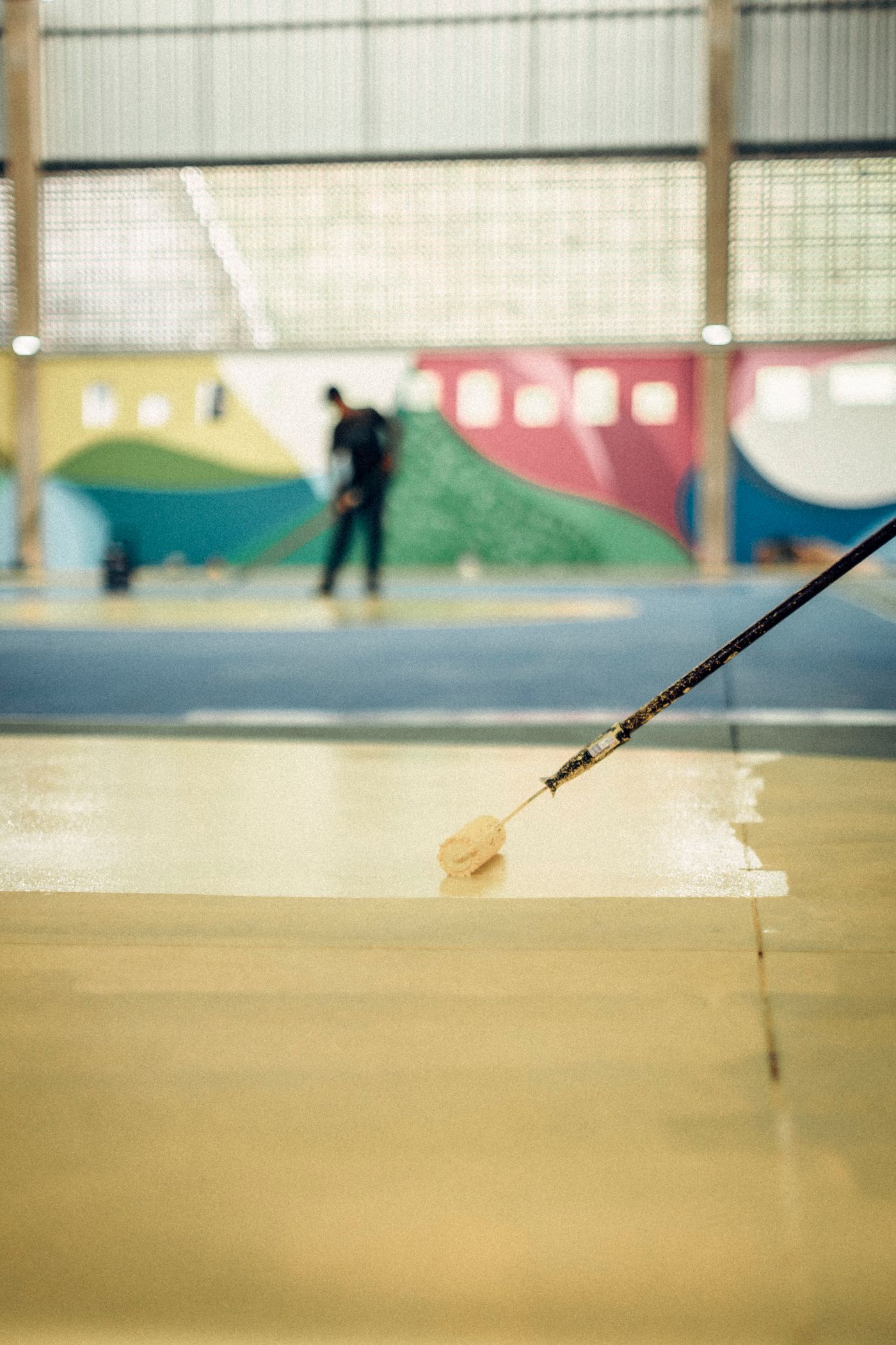 Example photograph of epoxy resin being spread across a concrete slab, shown to illustrate how the coating goes down rather than a Gargus Wood Floors job.