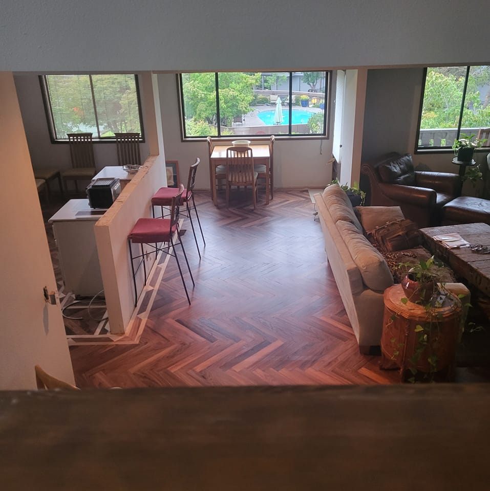 Herringbone flooring running through a living room with windows onto the Rogue Valley