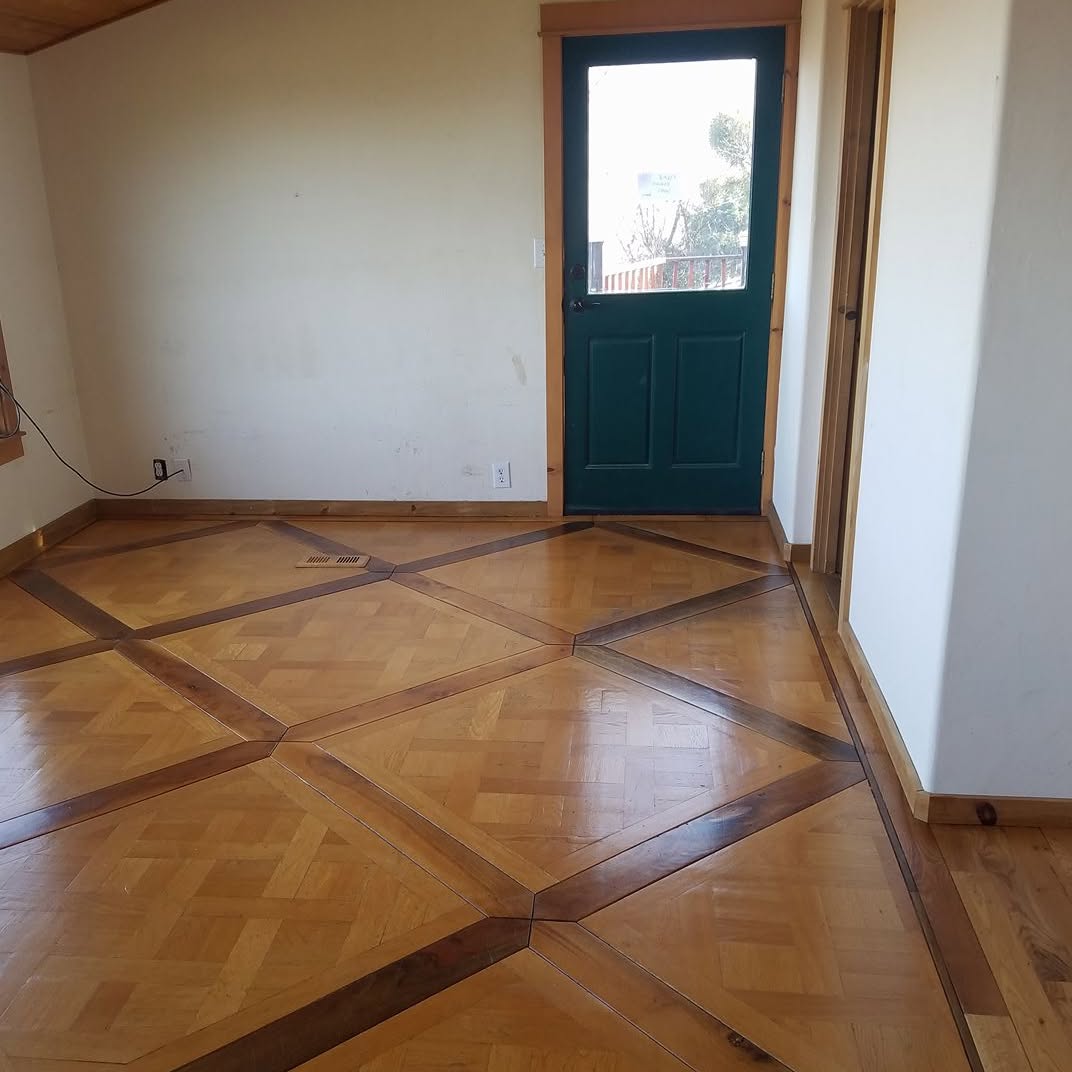 Parquet floor with a dark inlay border running around the room
