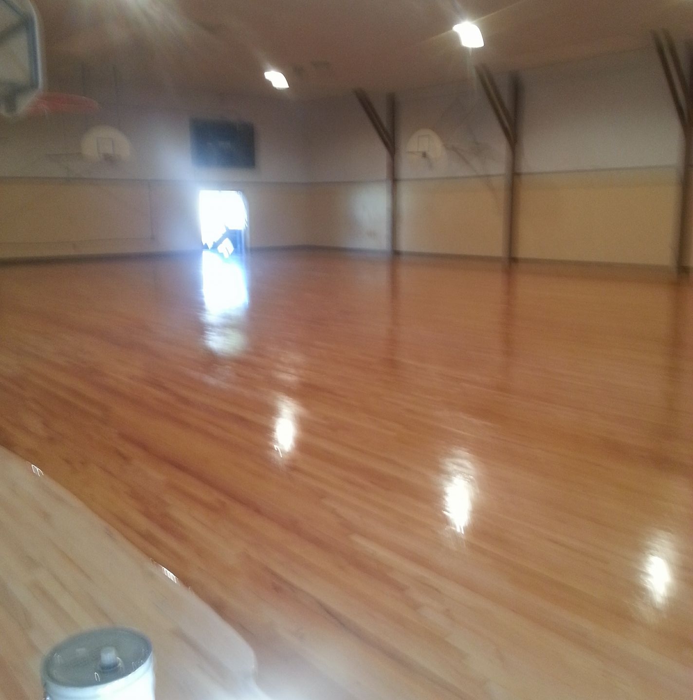 A refinished hardwood floor reflecting the ceiling lights