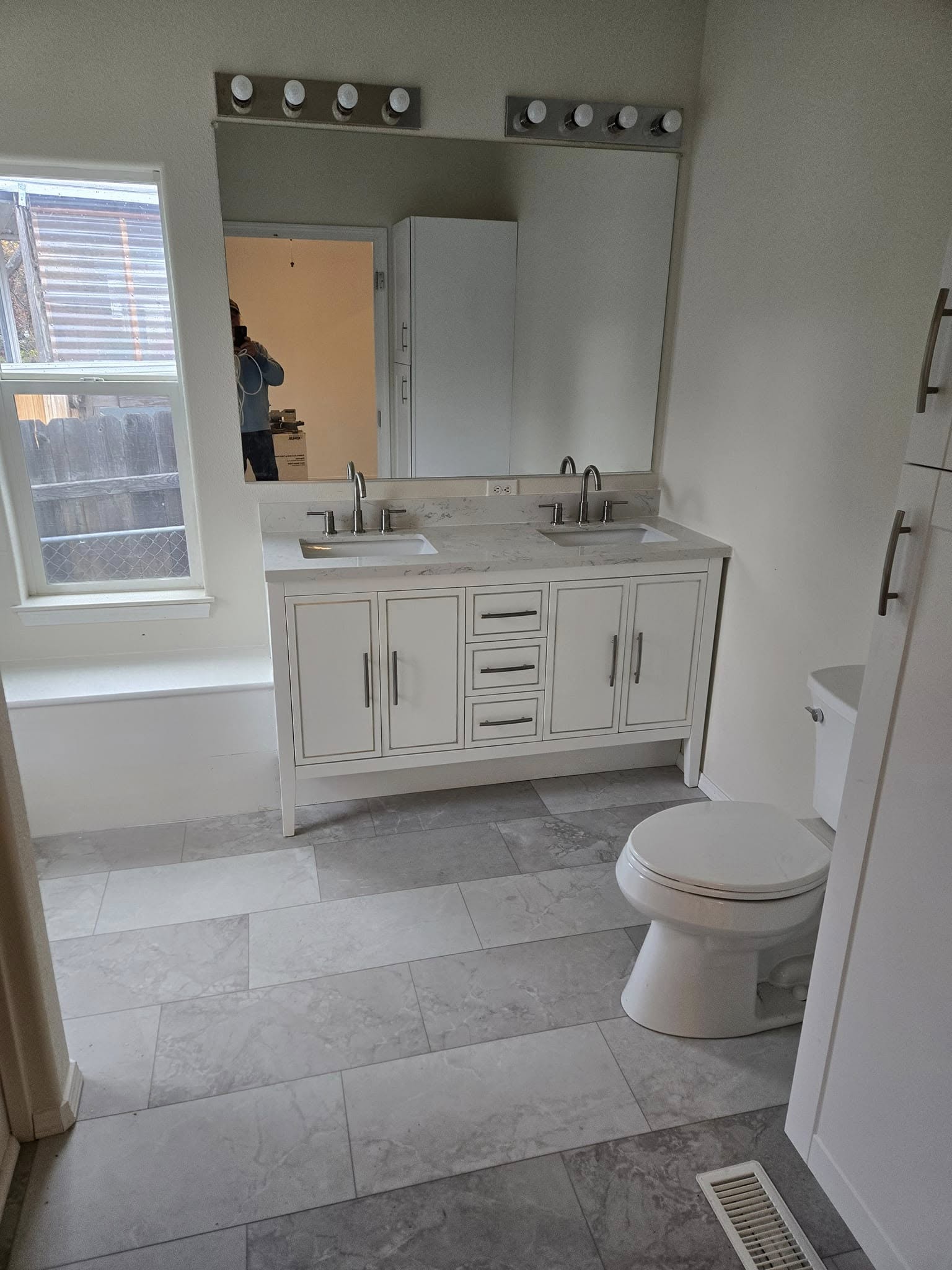 A tiled bathroom floor laid up to the vanity and doorway